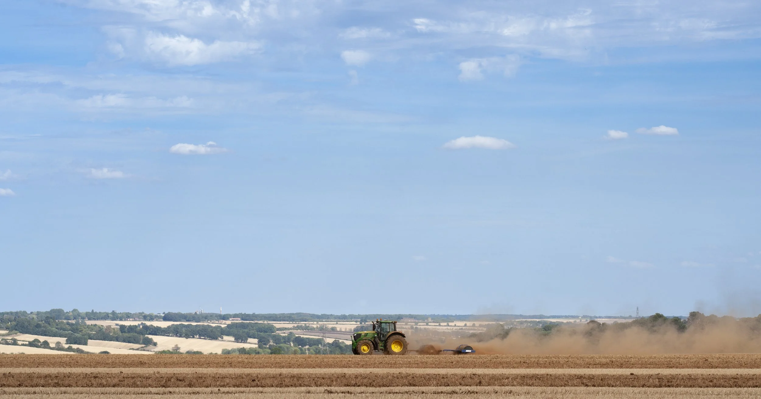 A tractor turns over the stubble causing a dust cloud of soil along the Ridlington ridge.