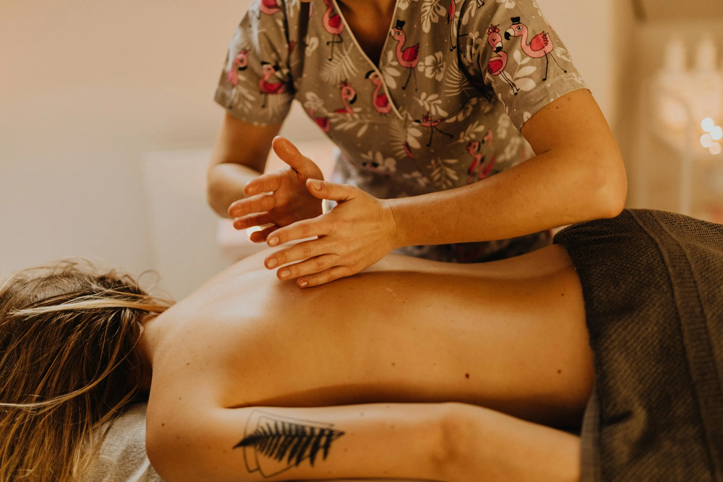 Una persona recibiendo una sesión de terapia de masaje en la espalda por parte de una terapeuta, en un ambiente relajante.