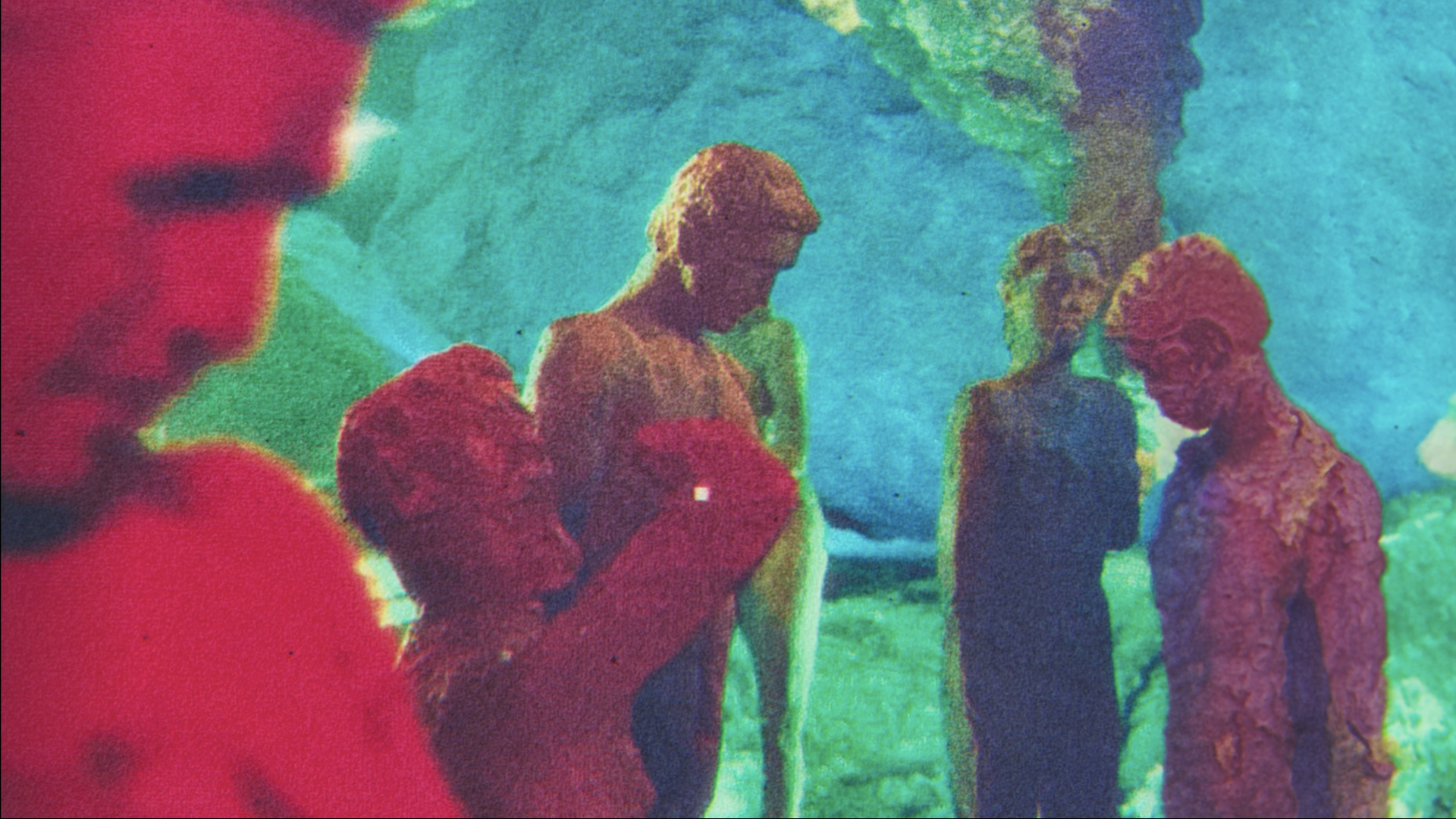 Colorful abstract art depicting a group of five people standing together, with one person in a red shirt, another in a yellow shirt, and others in darker clothing, set against a vibrant background of green, blue, pink, and purple hues.