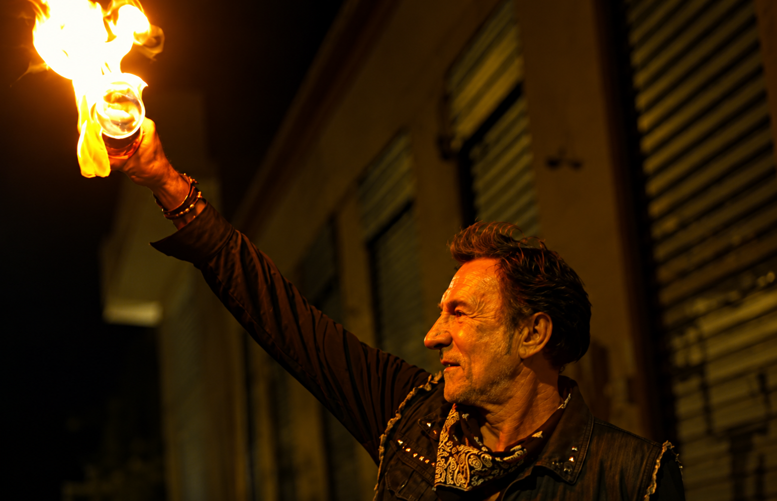 A man holding a flaming torch at night