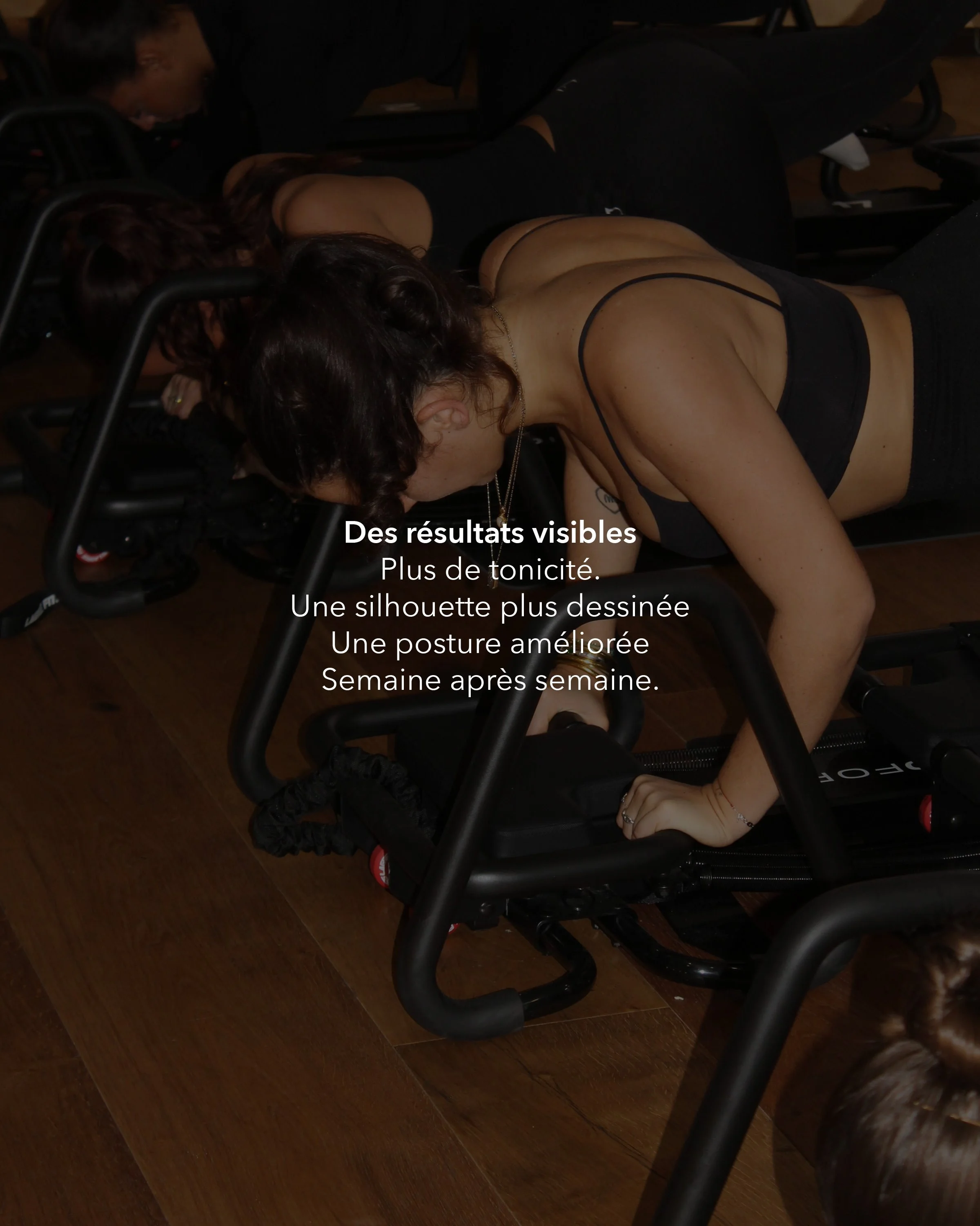 Three women in black sports bras and black leggings practicing fitness exercises on wooden floor with chairs around. Text overlay in French promotes fitness results.