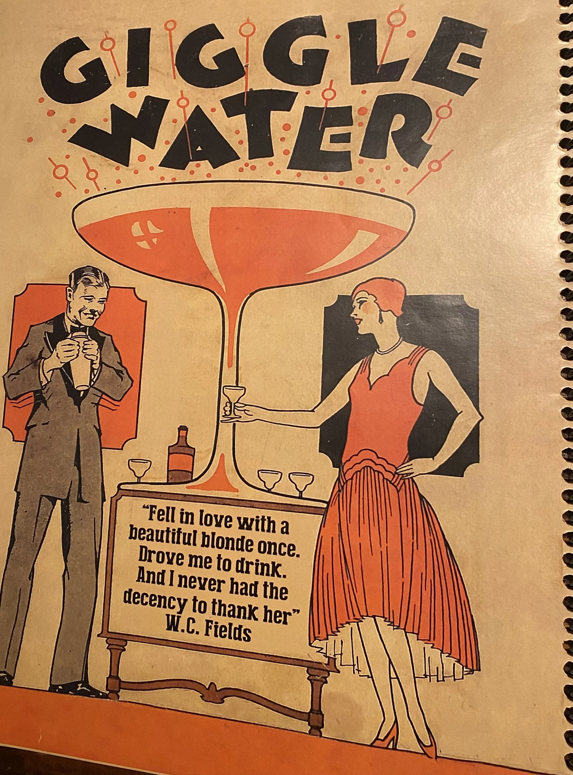 Vintage illustration of a man in a suit holding a drink and a woman in a red dress with a pleated skirt, standing next to a table with a framed quote by W.C. Fields. The quote reads: 'Fell in love with a beautiful blonde once. Drove me to drink. And I never had the decency to thank her.'