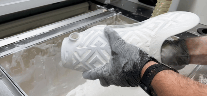 3D printed prosthetic parts being unpacked from a print bed at the HP Processing Station during Quorum’s fabrication process.