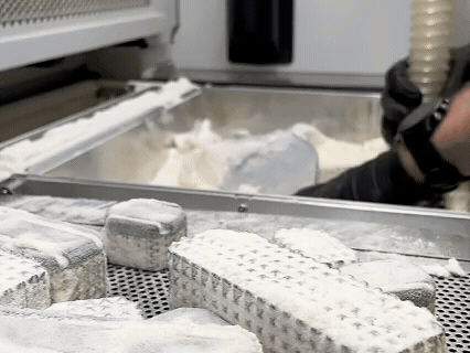 Animated GIF showing 3D printed Quatro Socket panels being processed to remove excess powder after printing.