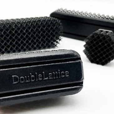 Close-up of black Quatro compression panels featuring flexible double lattice structures and an embossed ‘DoubleLattice’ label.