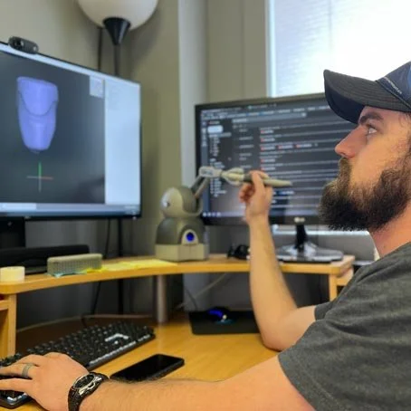 Sean designs a 3D prosthetic socket on a computer.