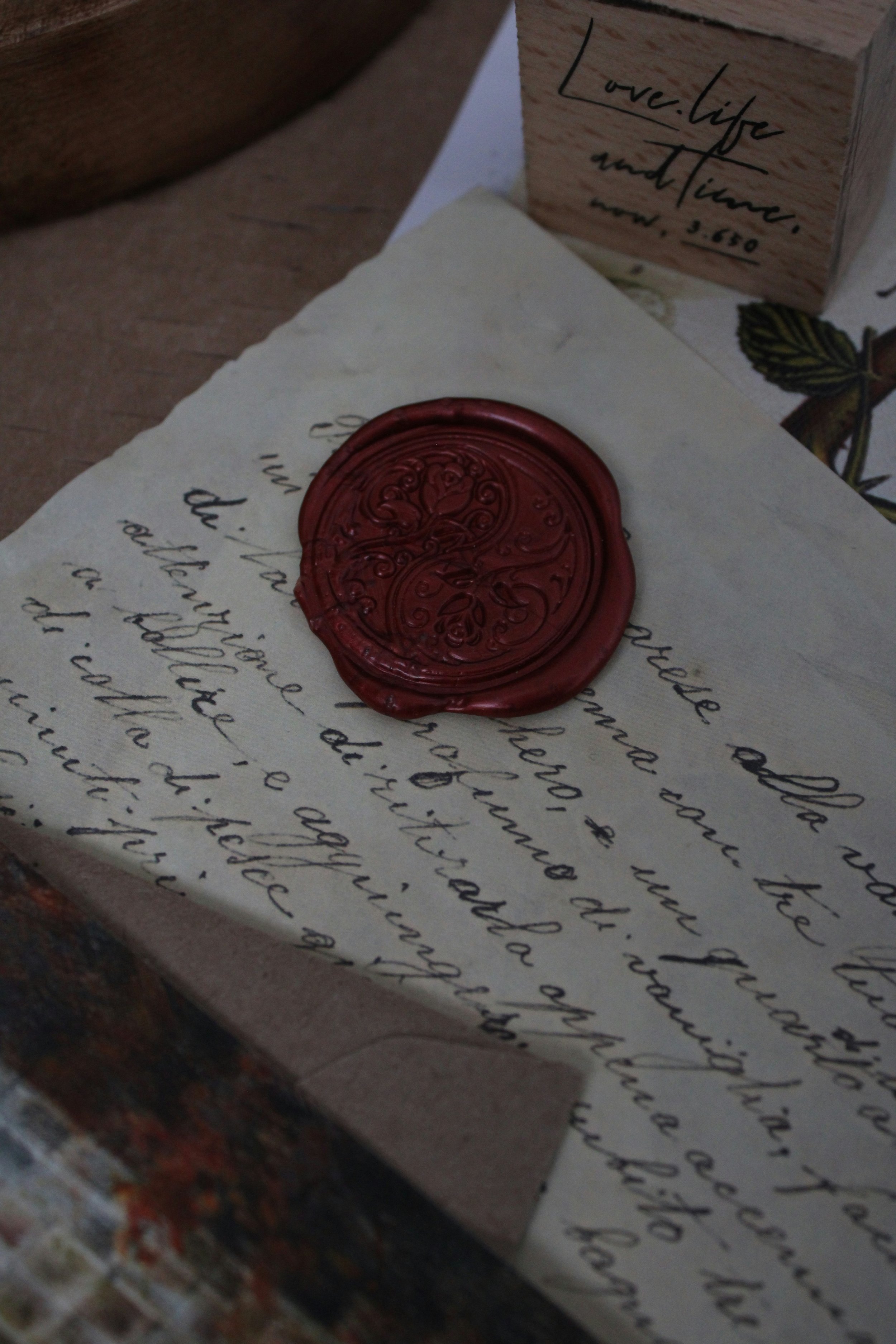 Close-up of a handwritten letter with a red wax seal on the paper.