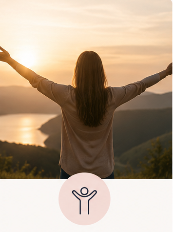 A woman with long hair standing outdoors at sunset with her arms raised, overlooking mountains and a body of water.