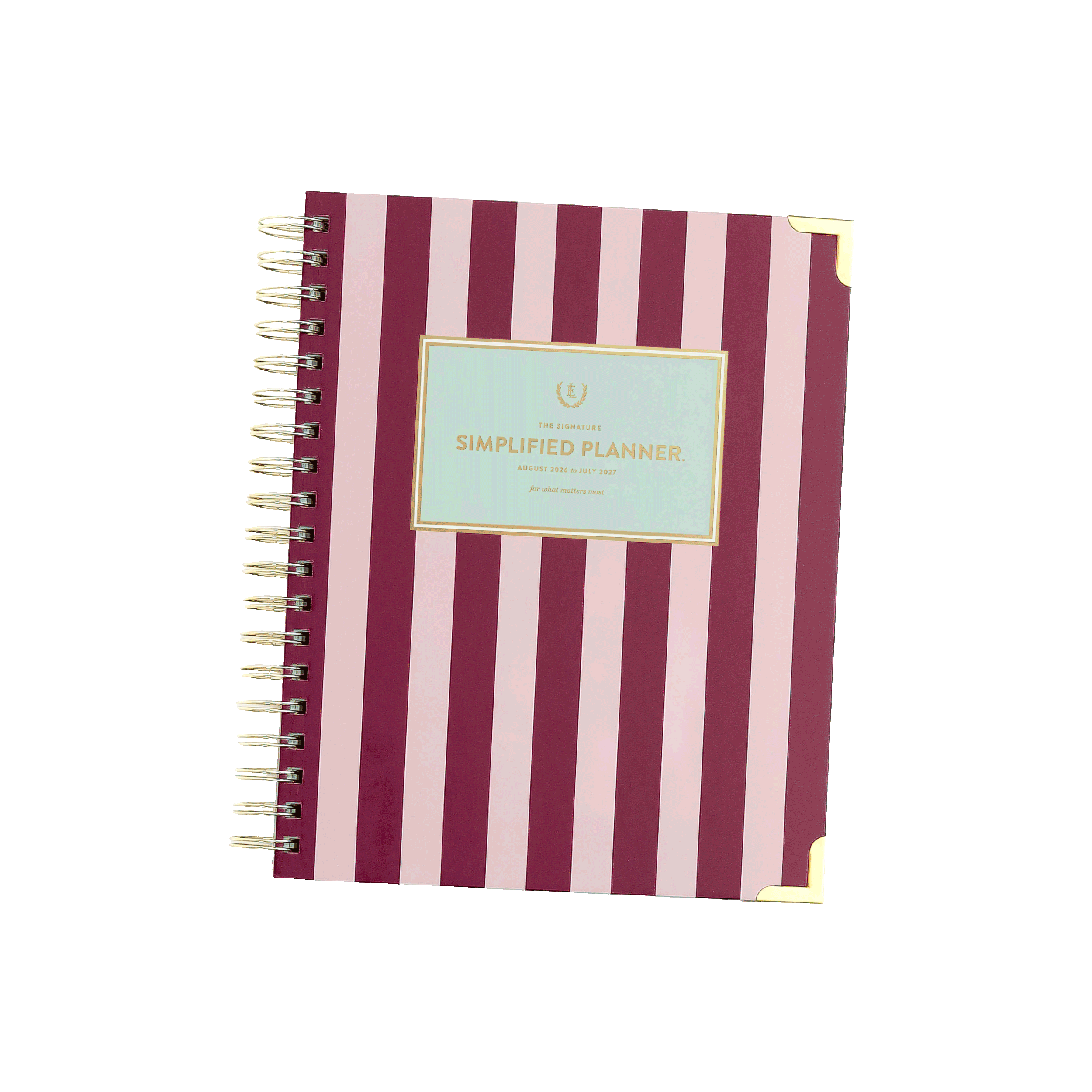 A pink and white striped spiral-bound planner with a gold foil label on the cover that reads 'Simplified Planner'.