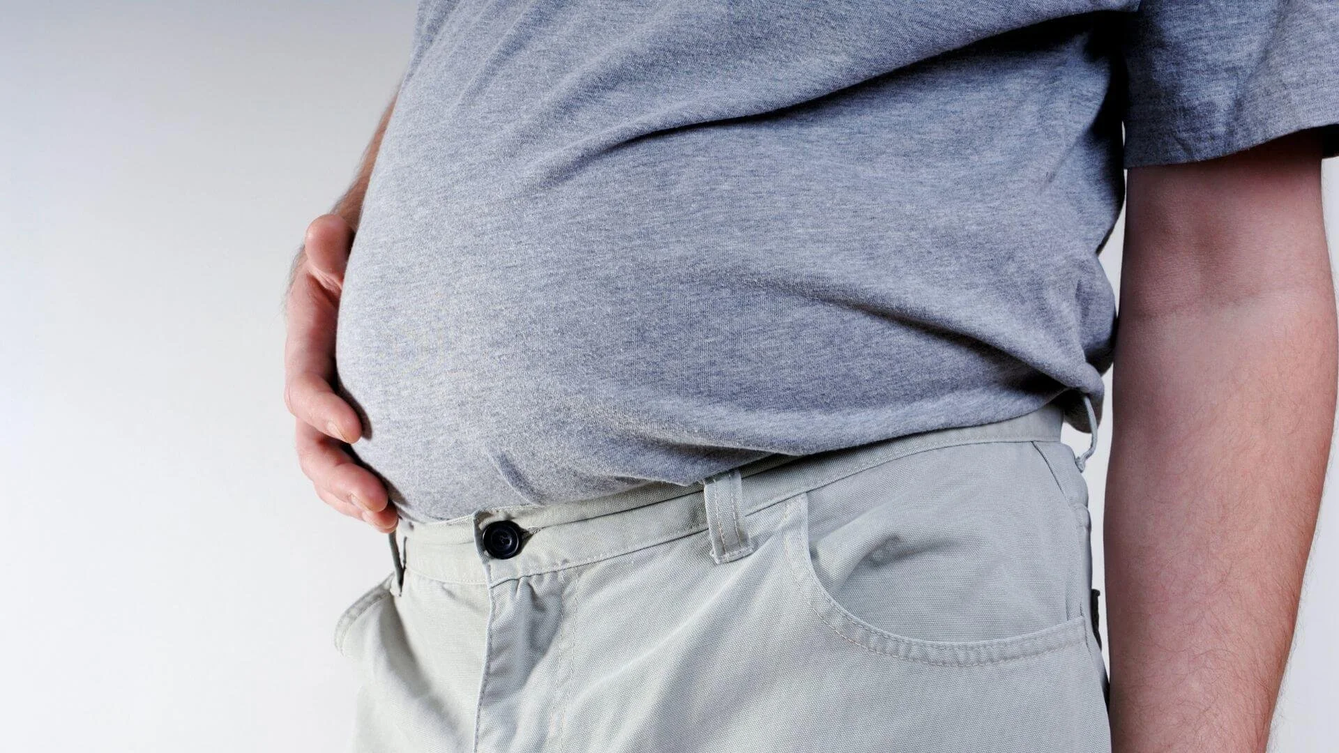 man holding his oversized belly