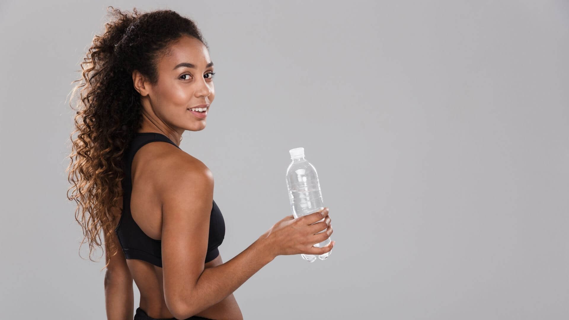 woman in athletic gear drinking water