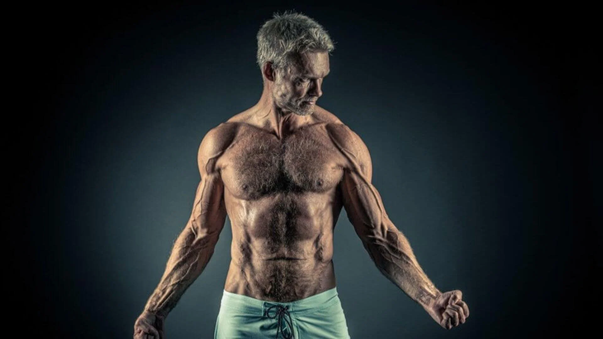 man holding his clenched fists and showing his muscles