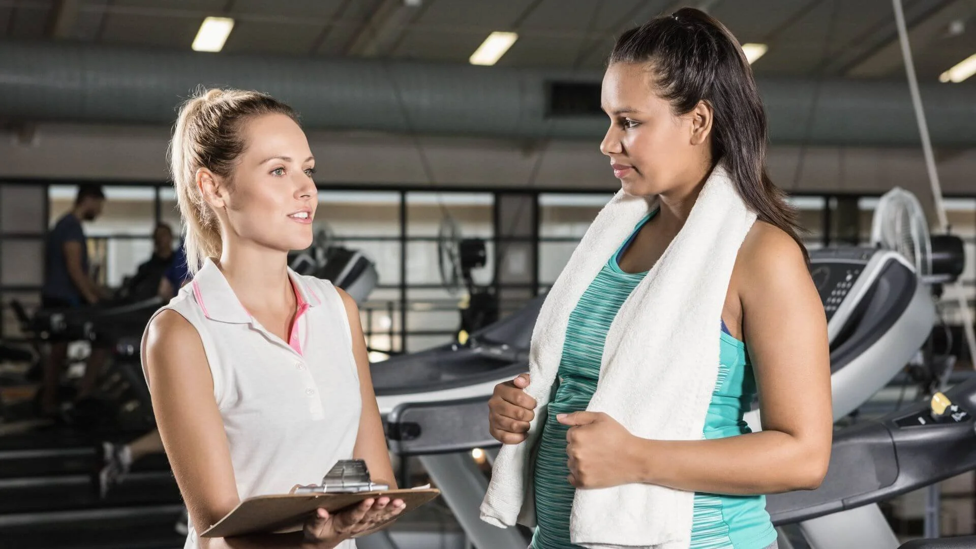 personal trainer talking with client to help them lose belly fat