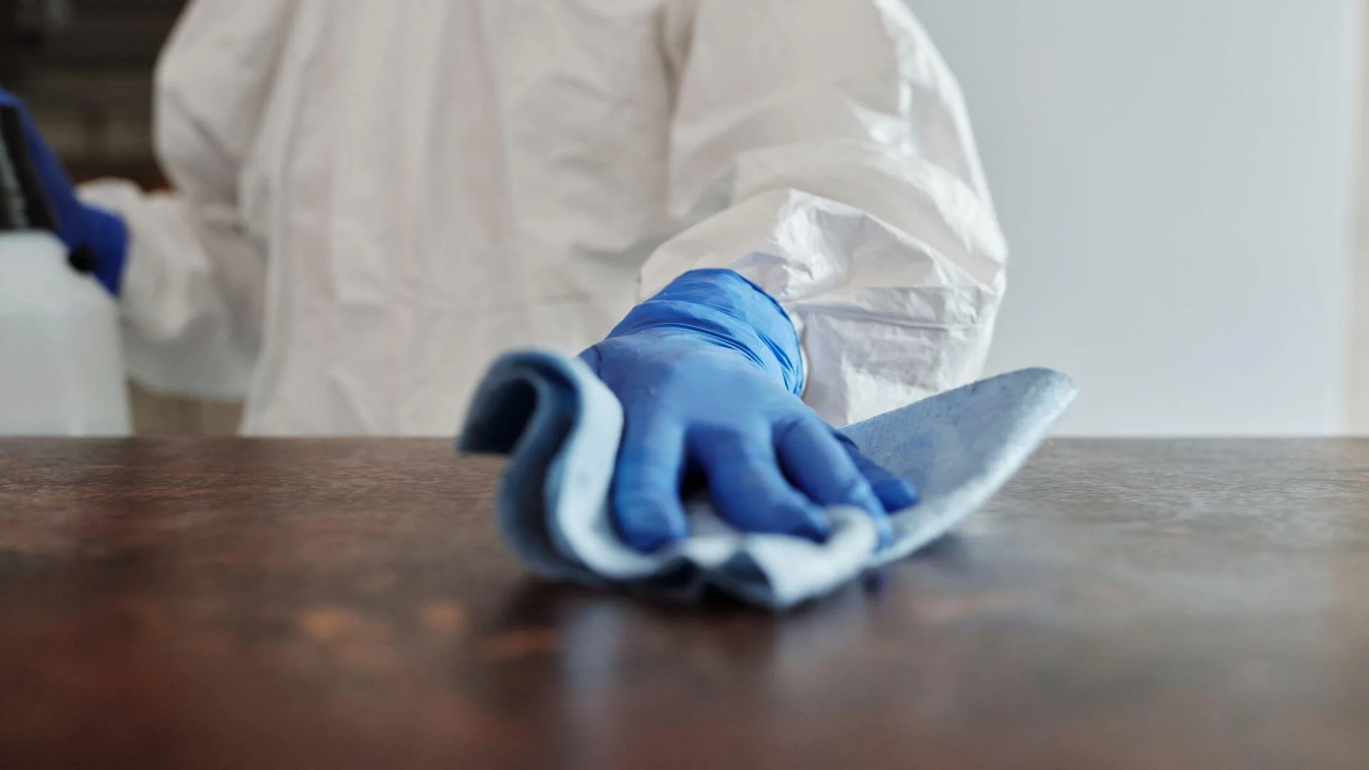 person in ppe cleaning a surface