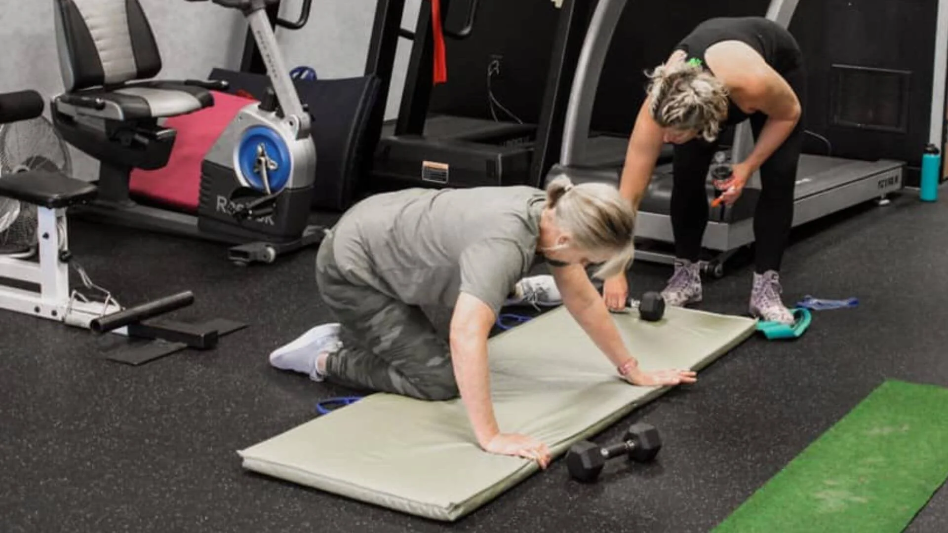 personal trainer helping a client exercise