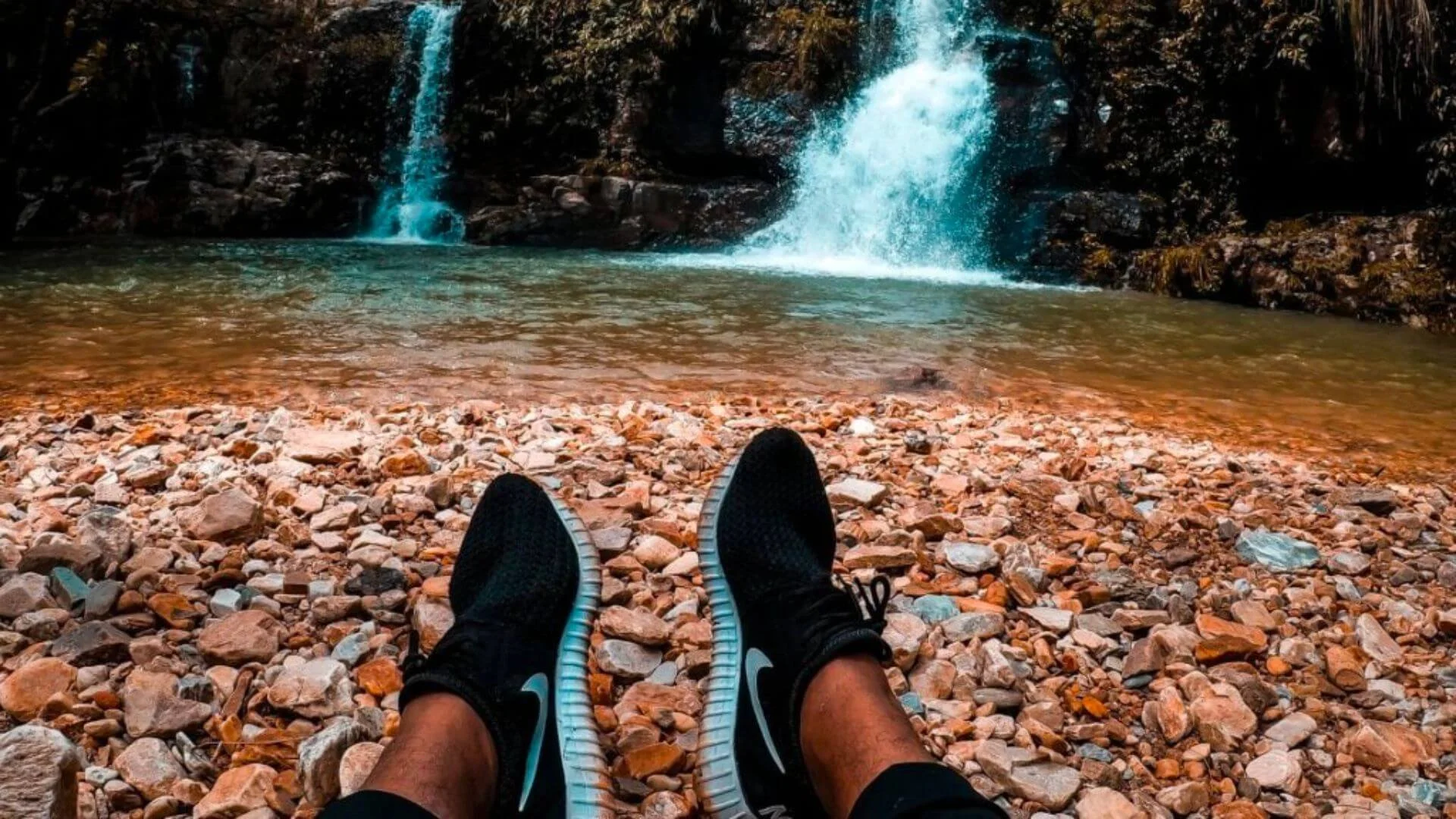 person sitting at a waterfall as a workout recovery
