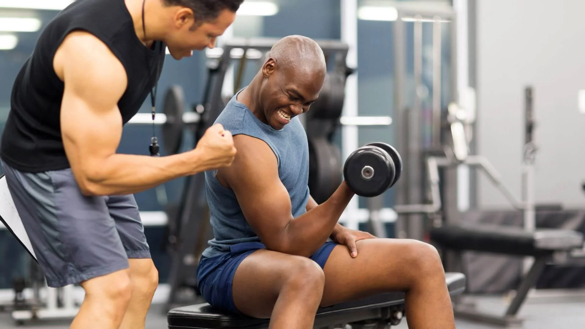 a personal trainer cheering on his client who's exercising