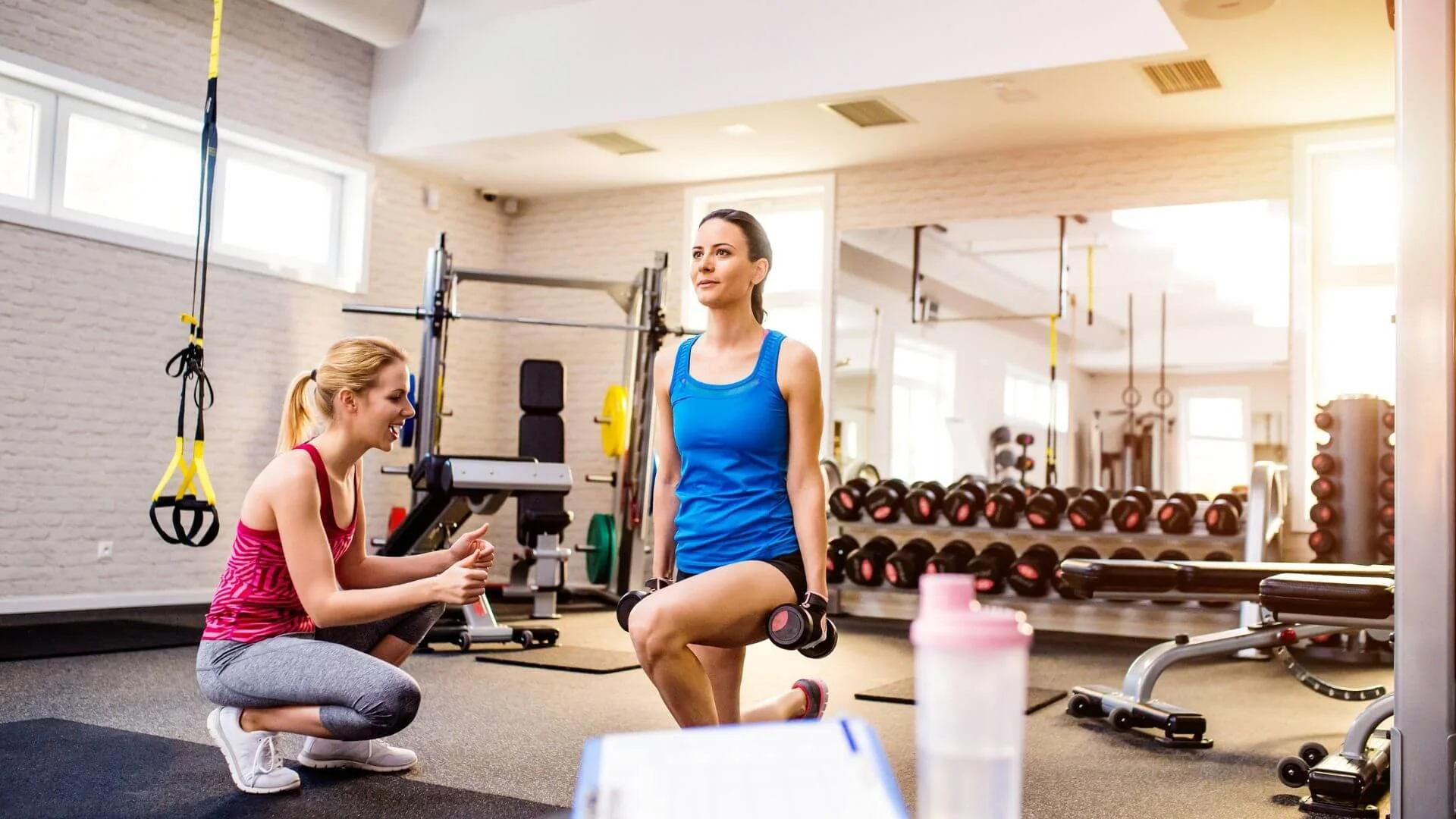personal trainer helping to encourage a client