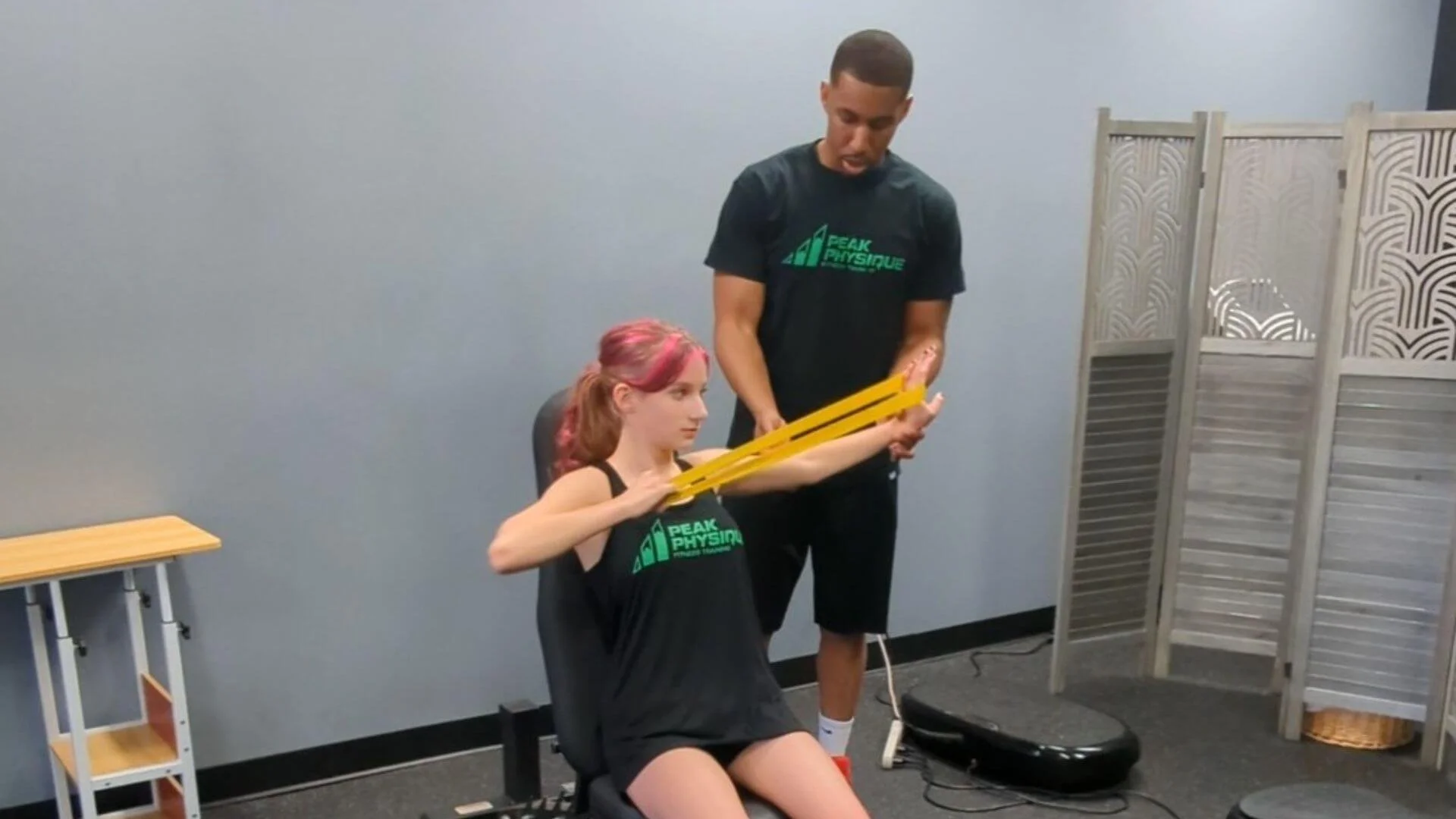 personal trainer helping a client exercise