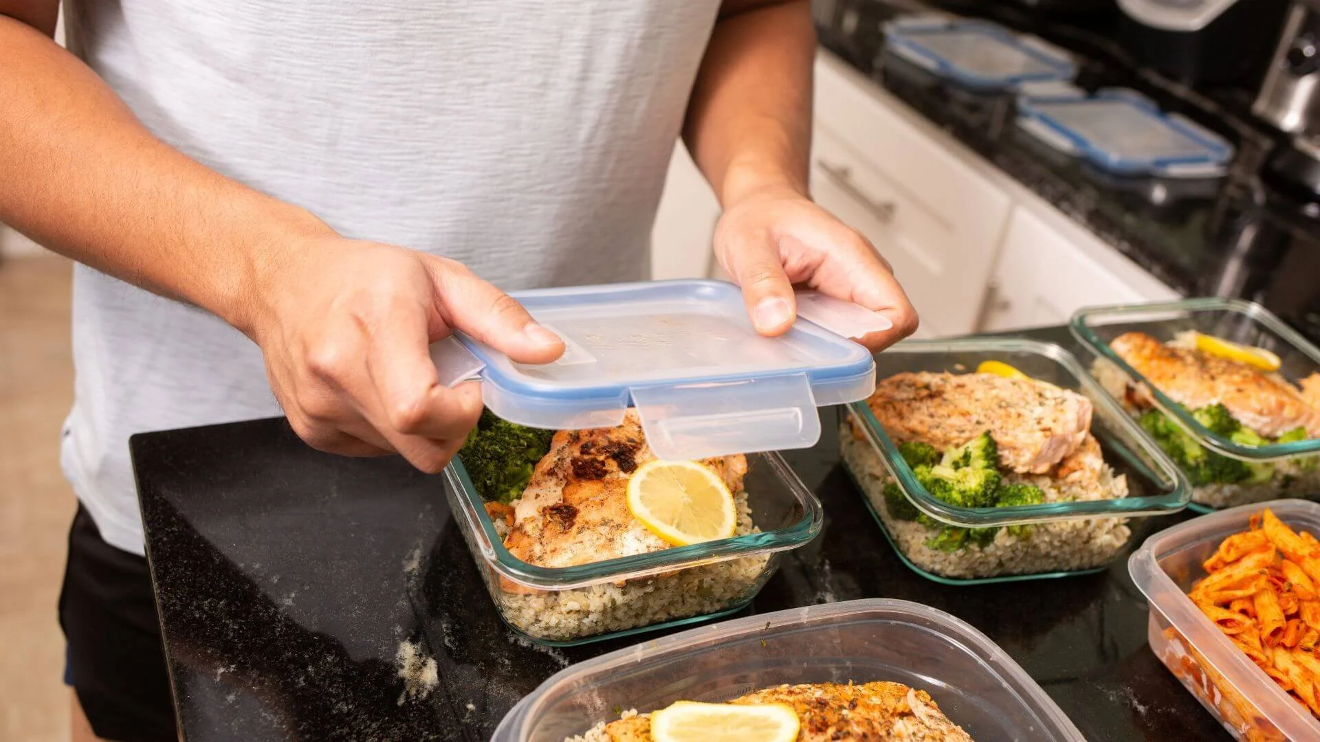 man closing up his healthy meal prep he just made