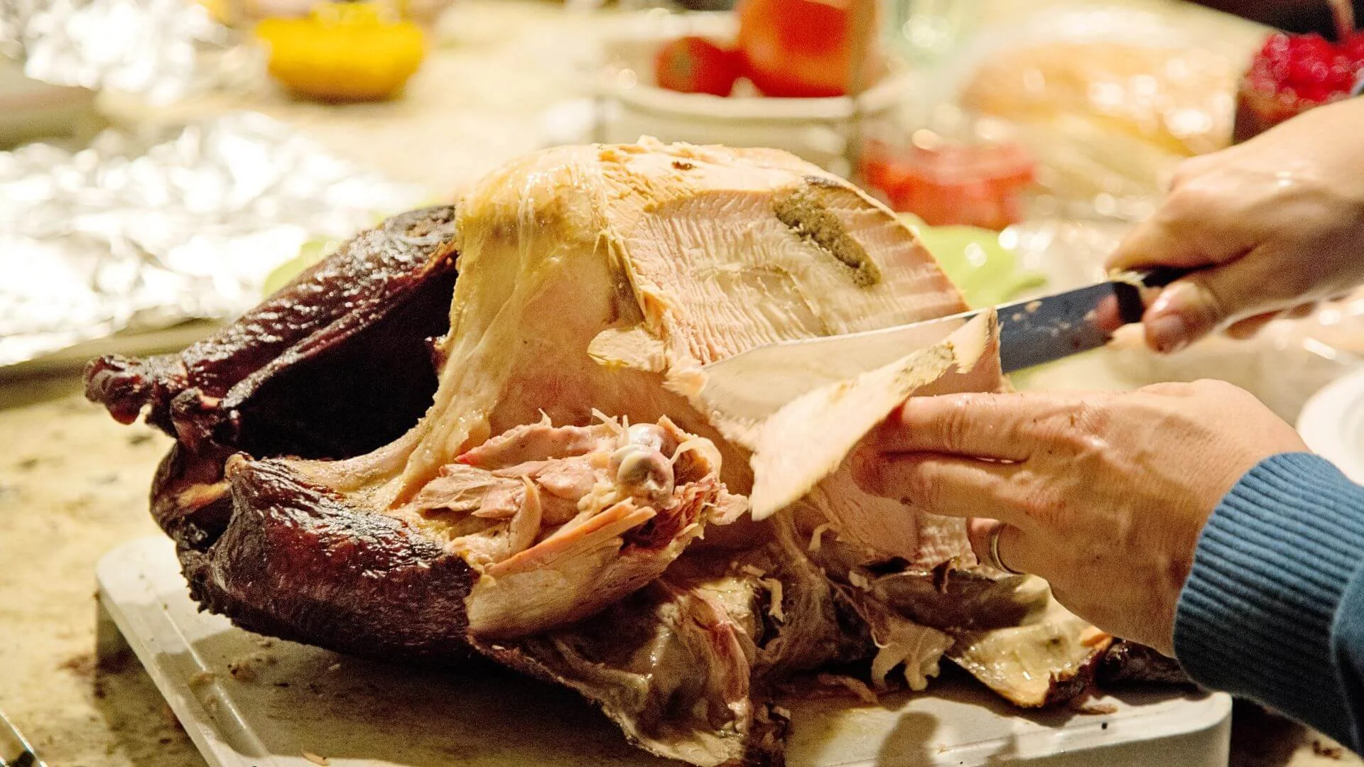 someone carving a thanksgiving turkey