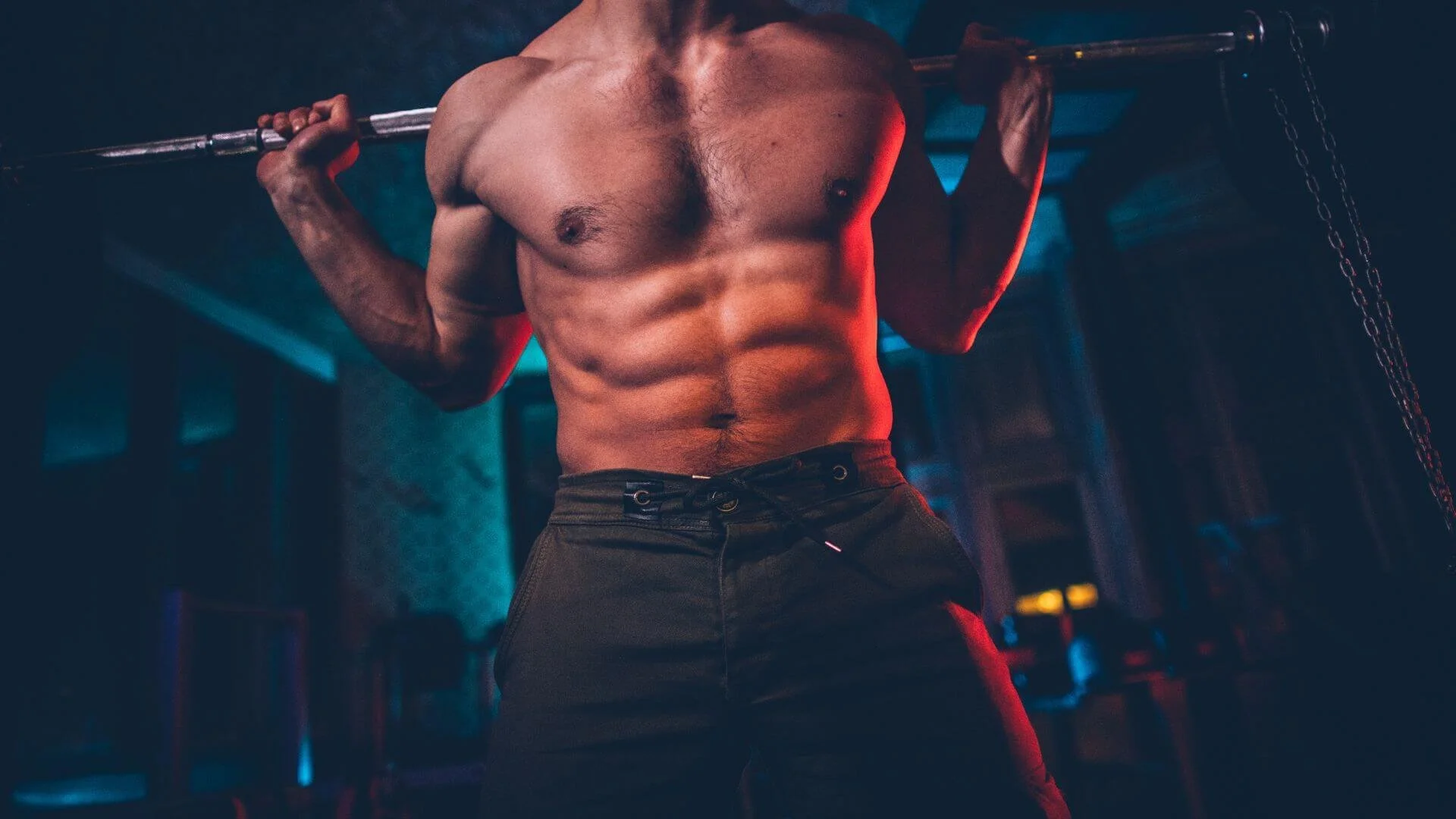 strong man lifting weights while showing his abs