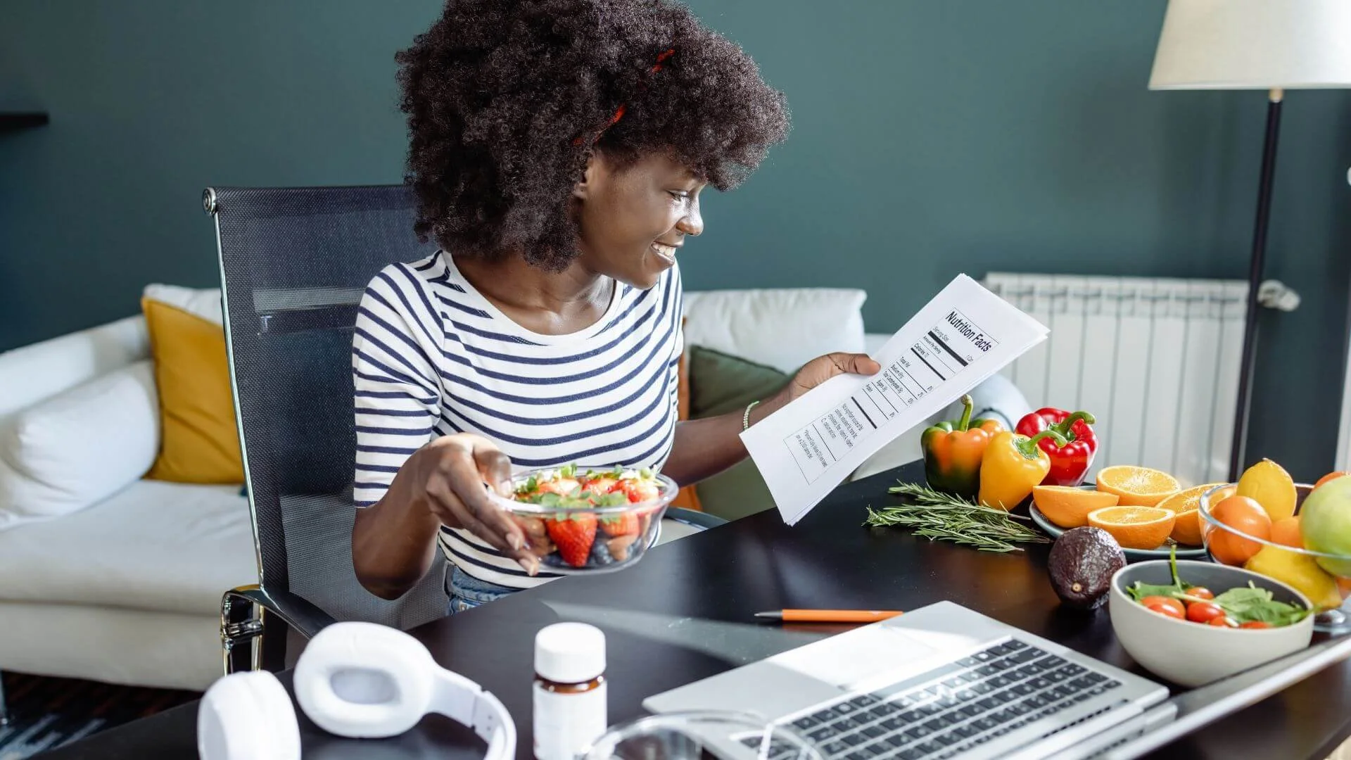woman happily eating healthy while she works