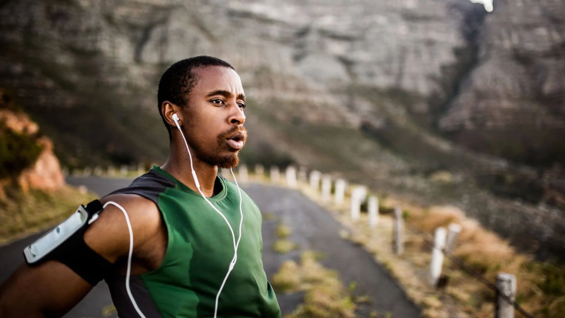 man taking a breath and focusing on breathing after running