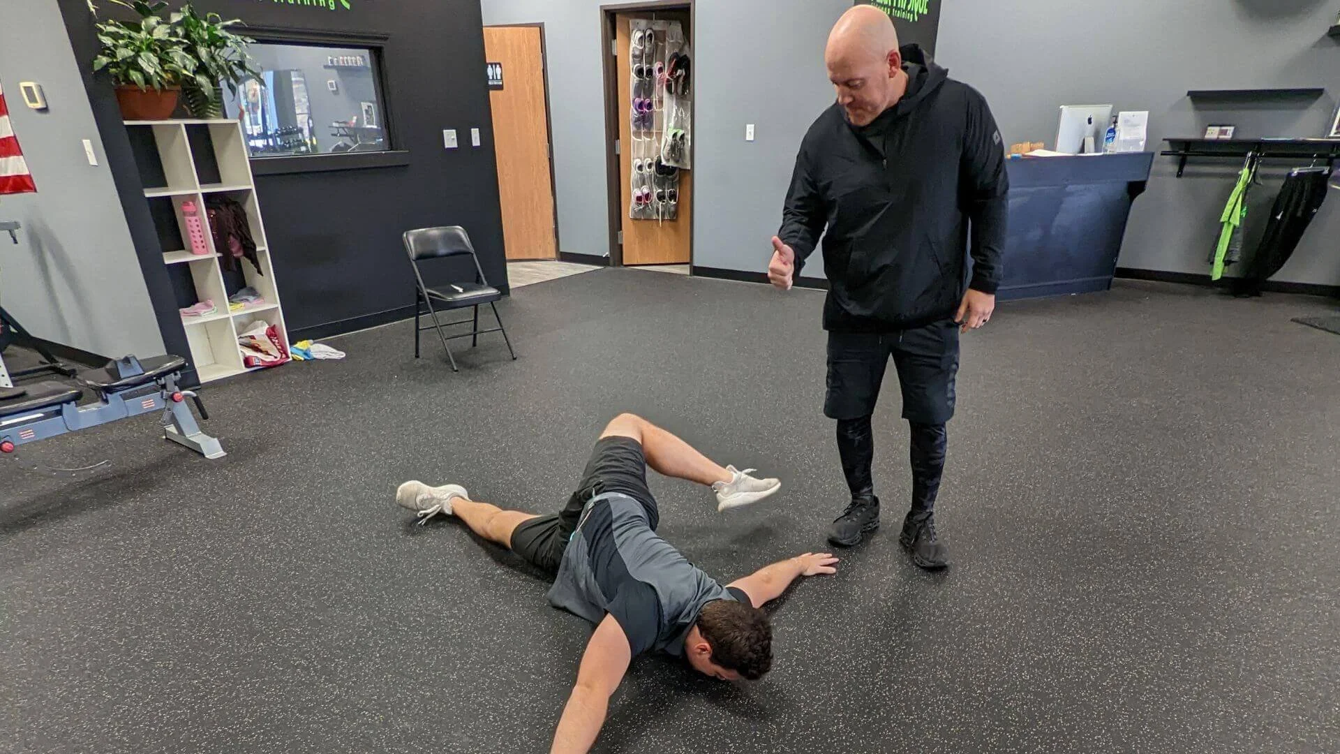 nick, personal trainer at peak physique giving a thumbs up to his client who is exercising in troy michigan