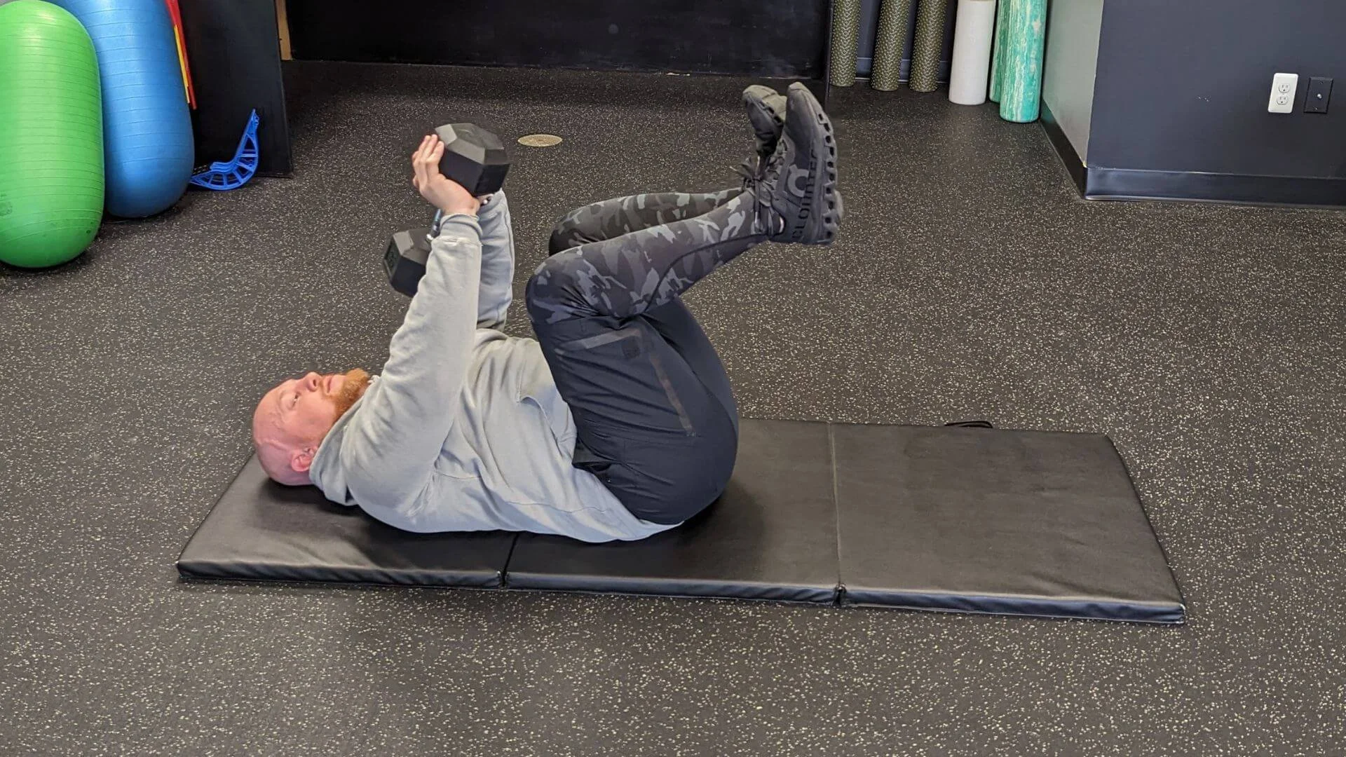Nick, personal trainer at peak physique, doing an exercise with his free weights