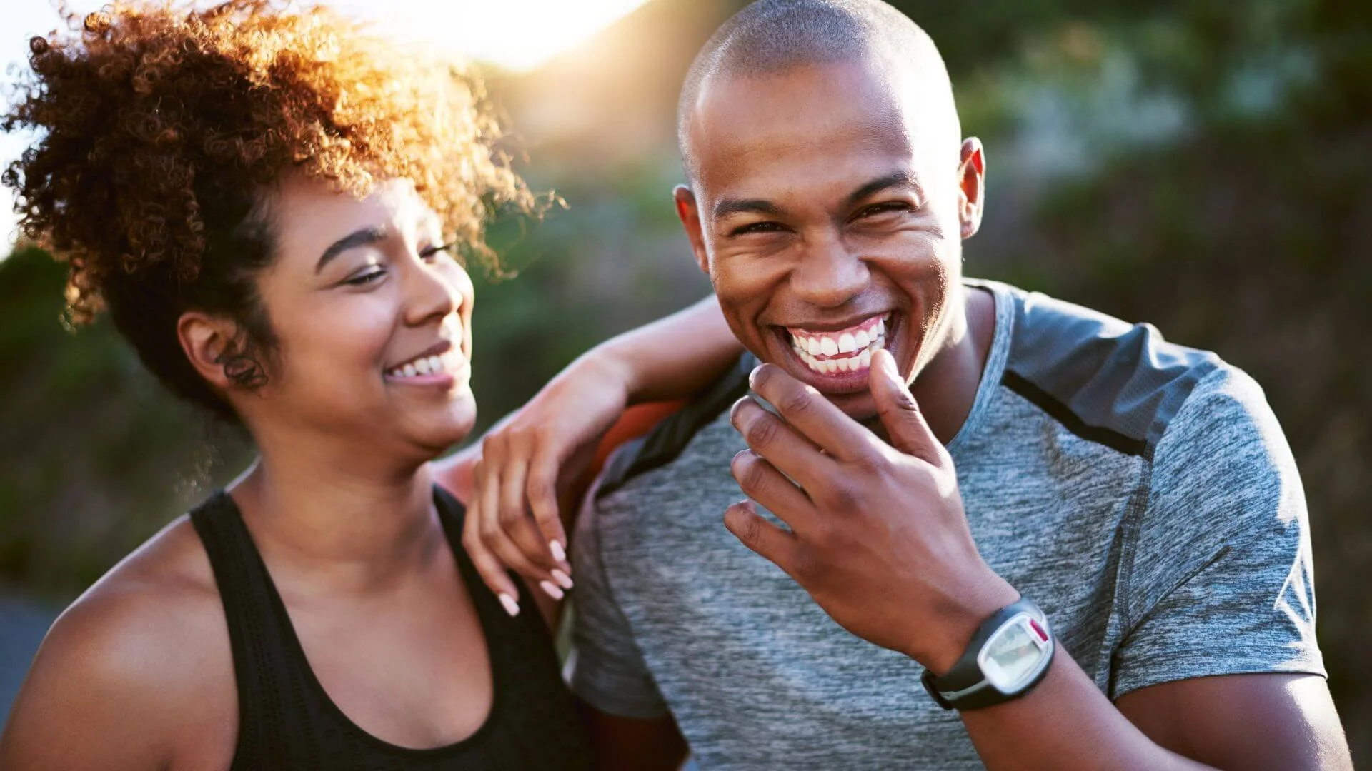 a couple laughing together and looking happy while exercising