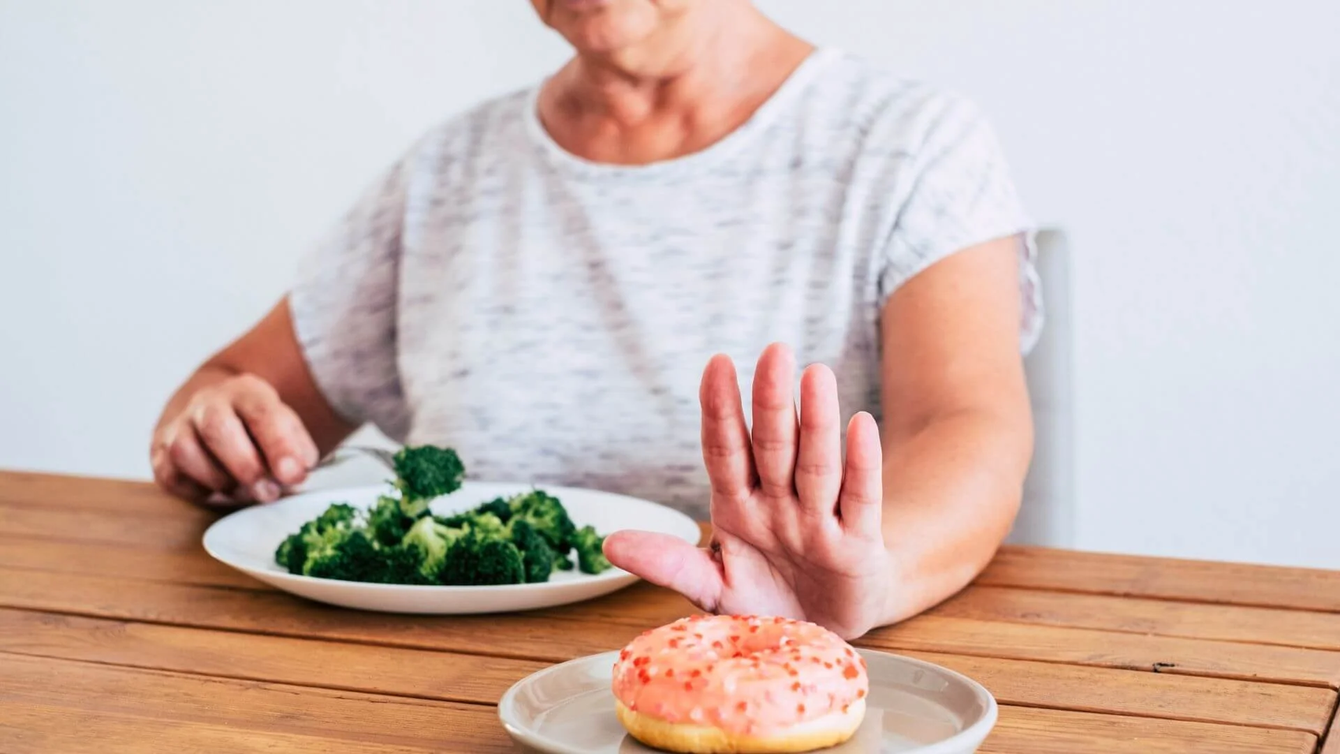 woman eating healthy and saying no to a donut