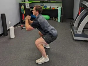 personal trainer showing how to do a squat