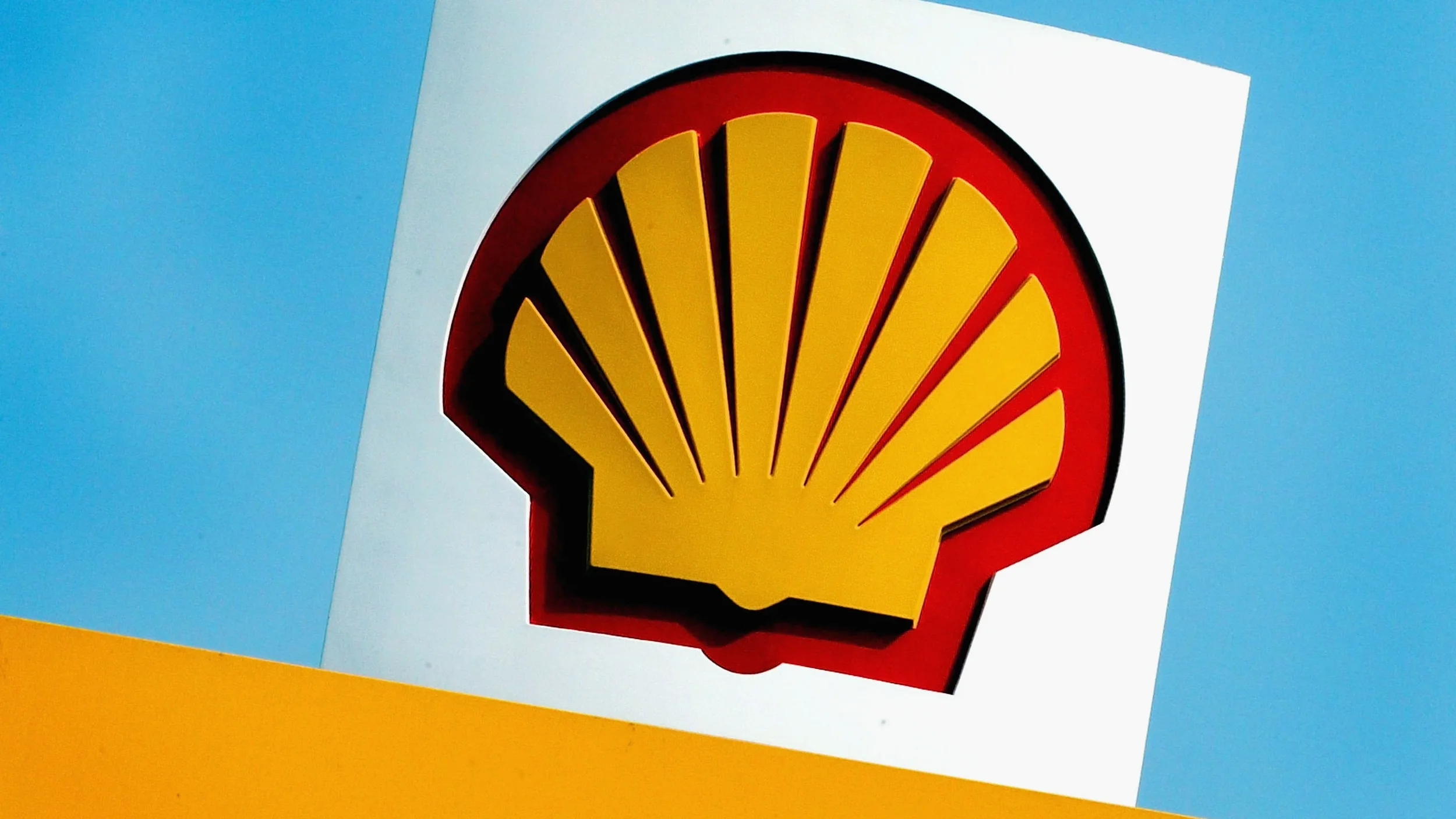 Shell logo with yellow shell shape and red outline on a white background with blue sky.