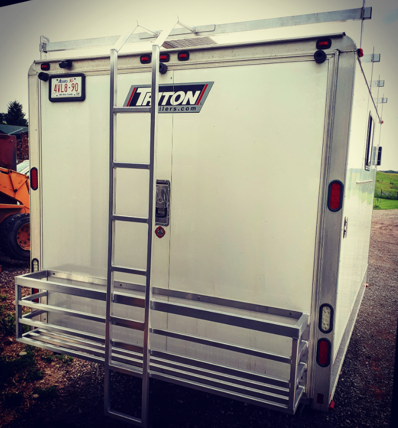 Back of a white cargo trailer with a ladder attached to it, a logo that says 'LADSON' and a license plate from California.