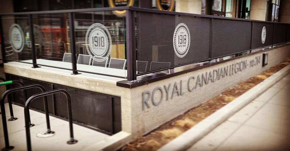 Exterior of a Royal Canadian Legion building with a glass partition and signage indicating the year 1918.