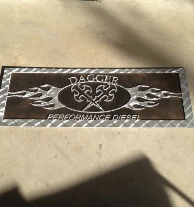 A metallic sign with the text "Dagger Performance Diesel," featuring an emblem of crossed daggers and flame designs.