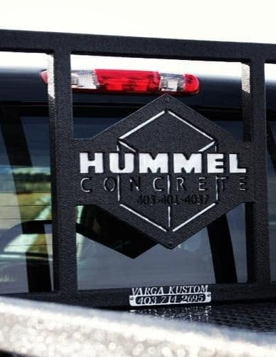 Hummel Concrete logo sign attached to a truck with a metal barrier in the foreground.