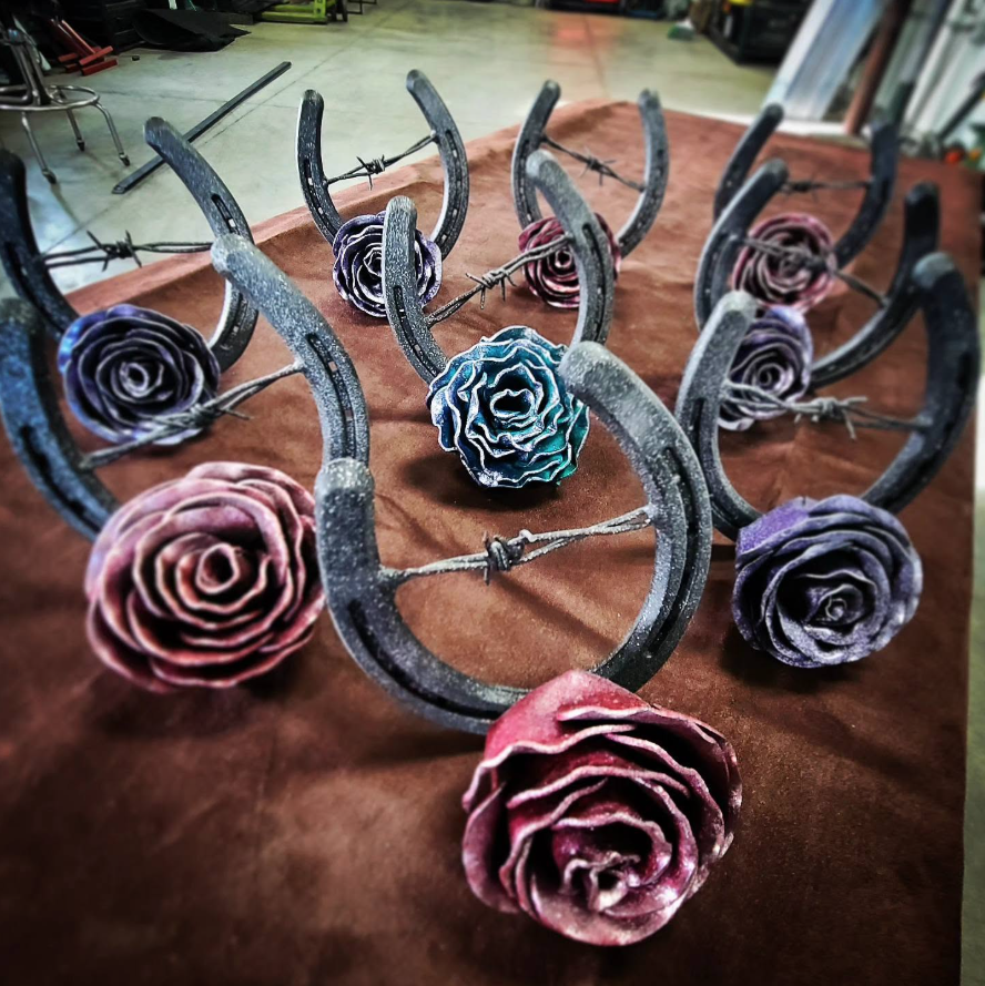 Metal horseshoe ladders with colorful rose decorations on a brown cloth surface.