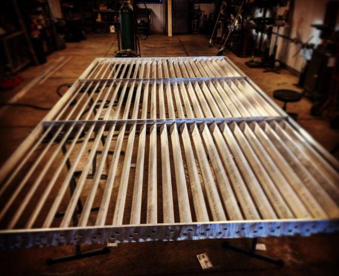 Wooden bed frame with slats in a woodworking shop.