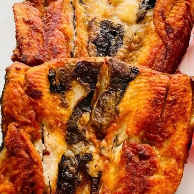 Close-up of two slices of pizza with cheese, tomato sauce, and grilled mushrooms on a white plate.