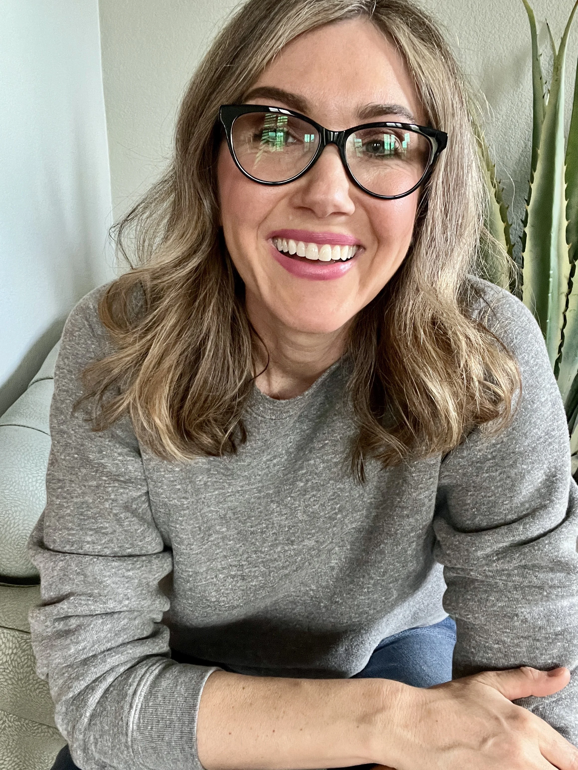 Author and CEO Jamie Moraga wearing grey sweatshirt and smiling at camera