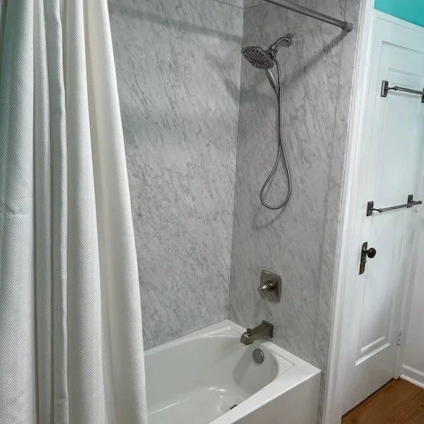 Bathroom remodel with marble-look shower surround, updated fixtures, and soaking tub – Tampa FL