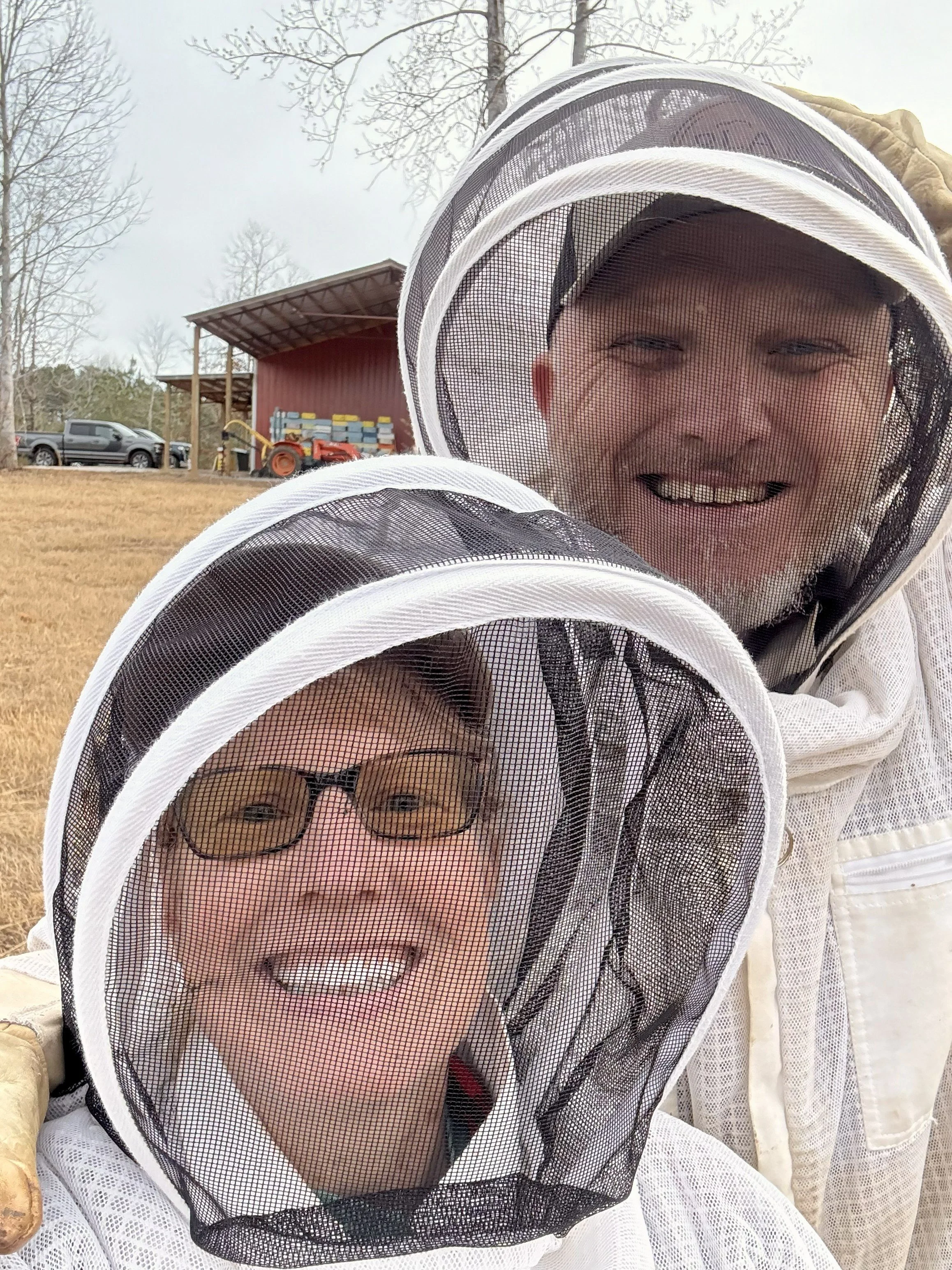 Kate and her husband Harry in beekeeping suits at the apiary.