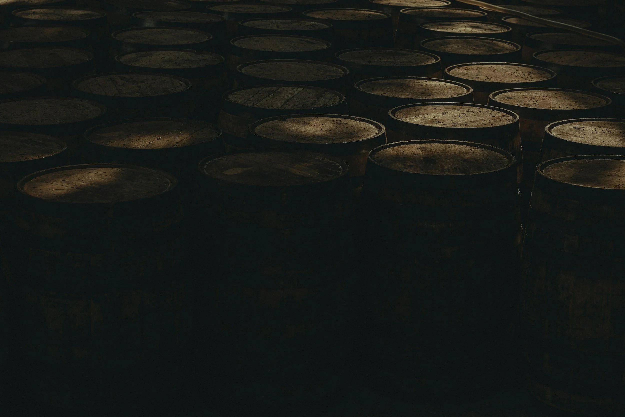 Scotch whisky casks ands in a dark warehouse