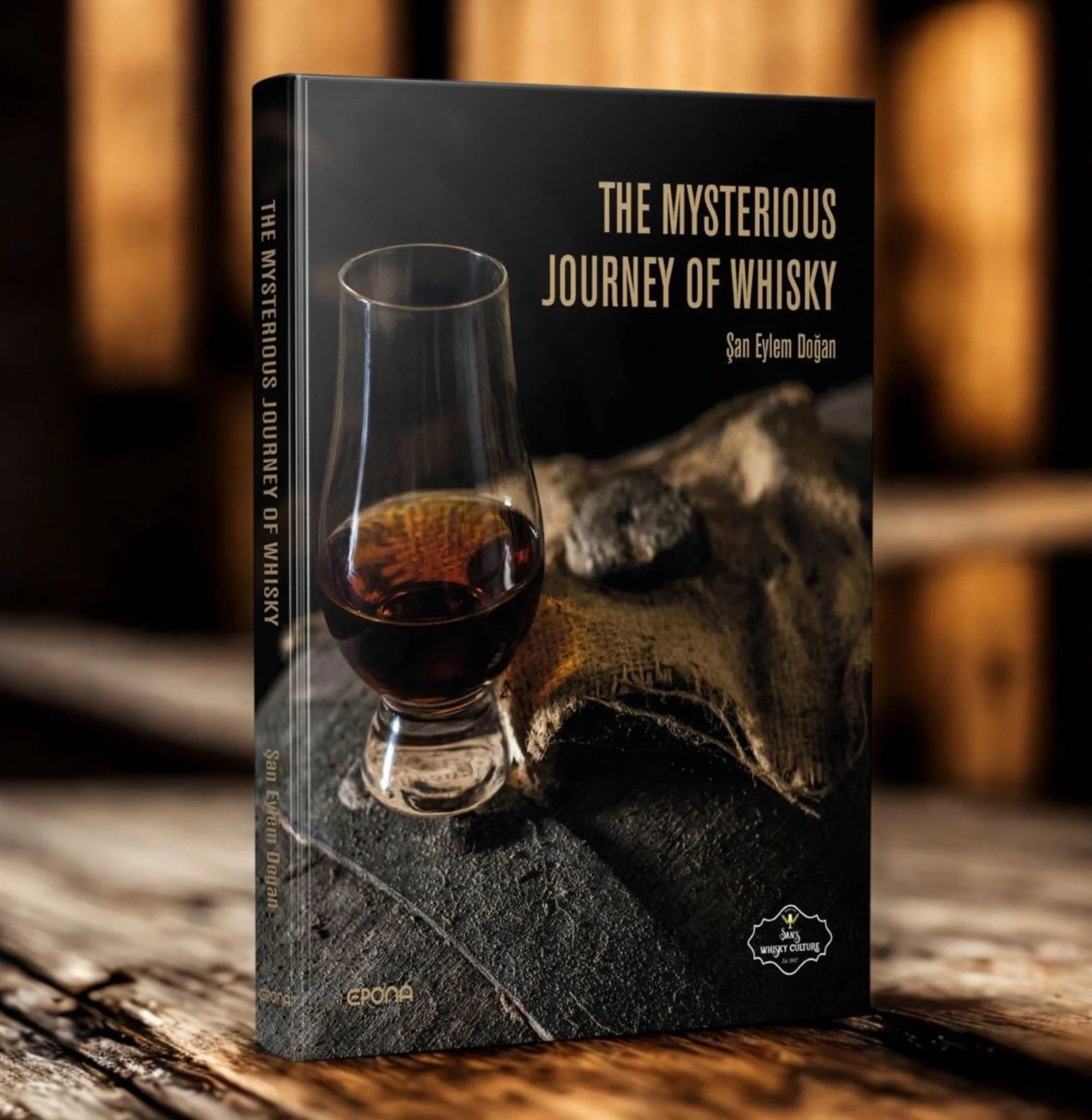 Book titled 'The Mysterious Journey of Whisky' by Şan Eylem Doğan, featuring a glass of whisky on its cover.