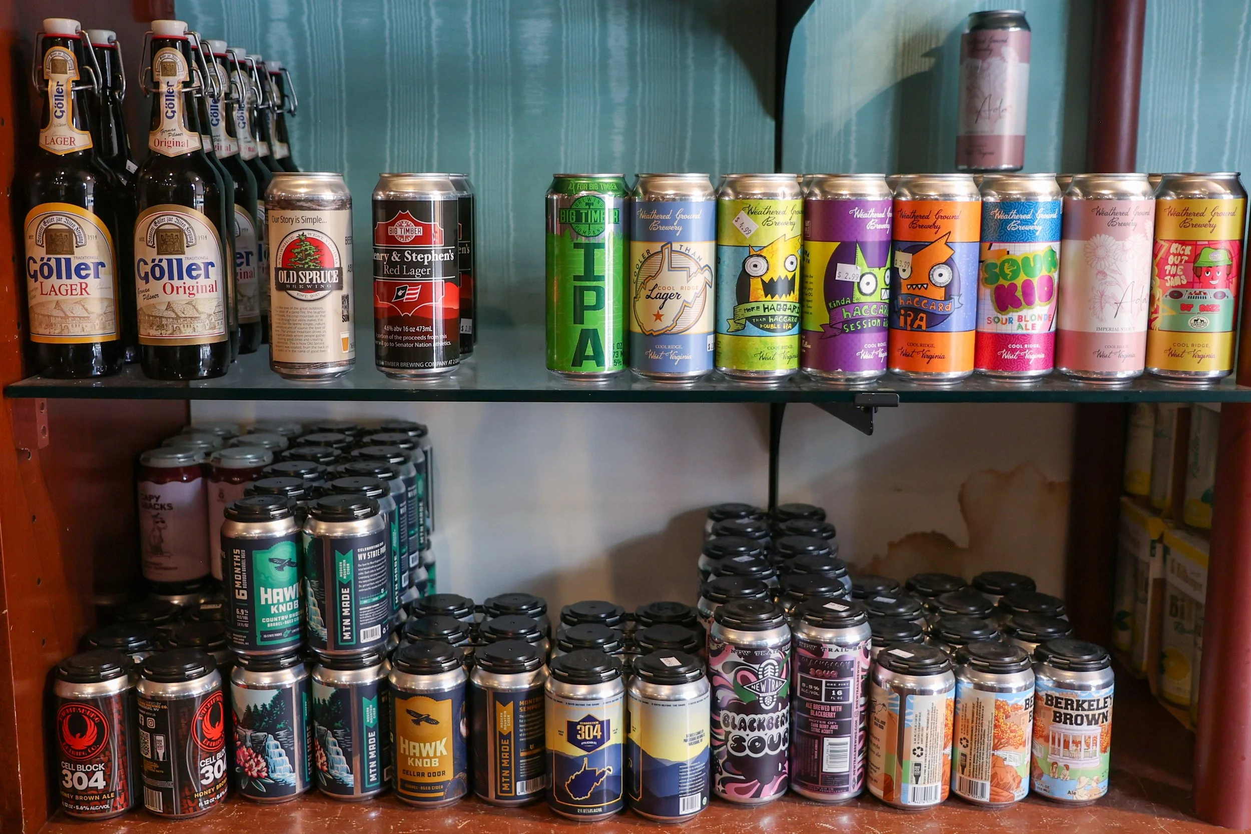 Shelf with assorted cans of craft beer in various colorful designs and labels.