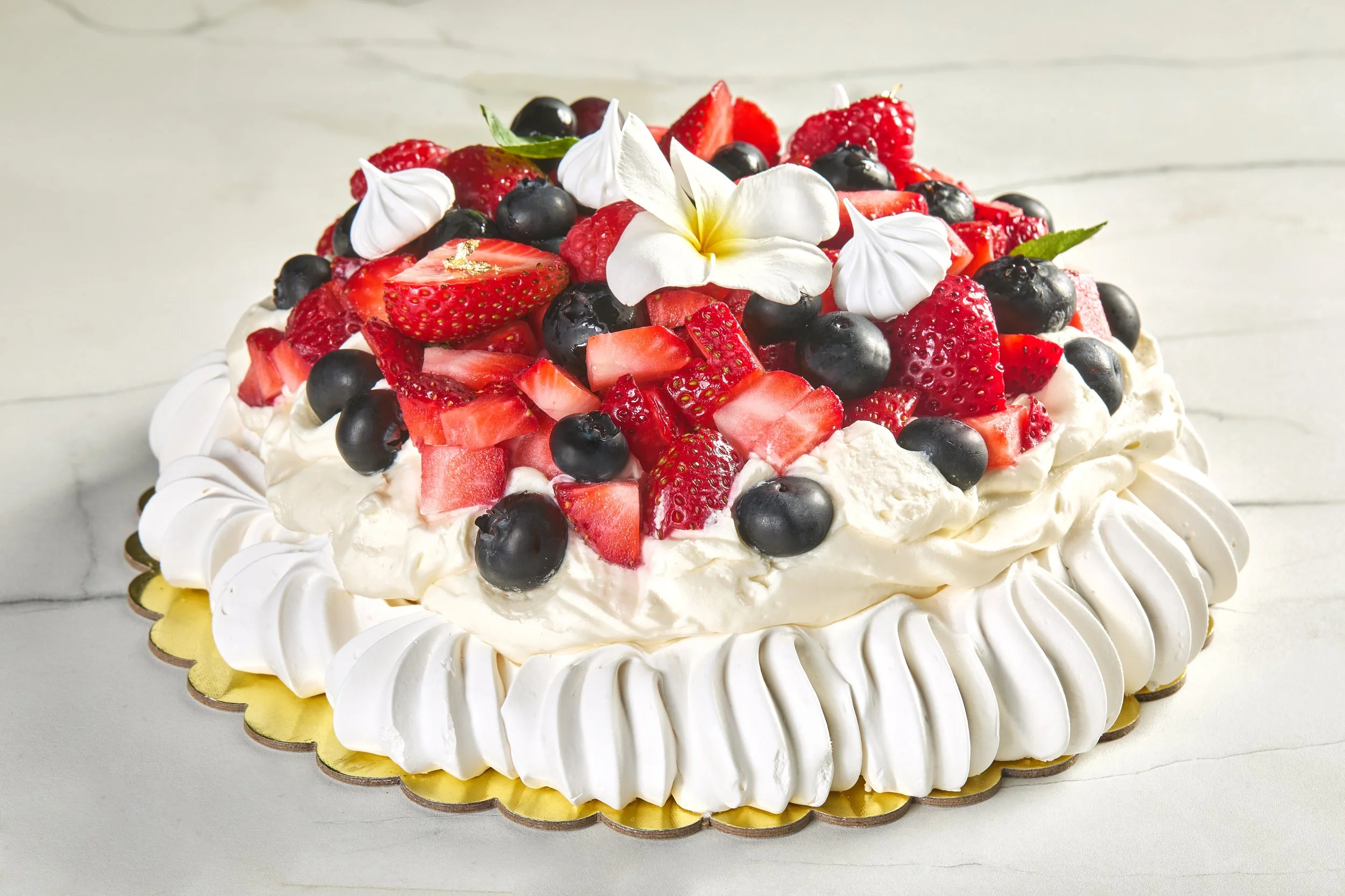 Pavlova naturalmente sin gluten con merengue, crema fresca y frutos rojos.