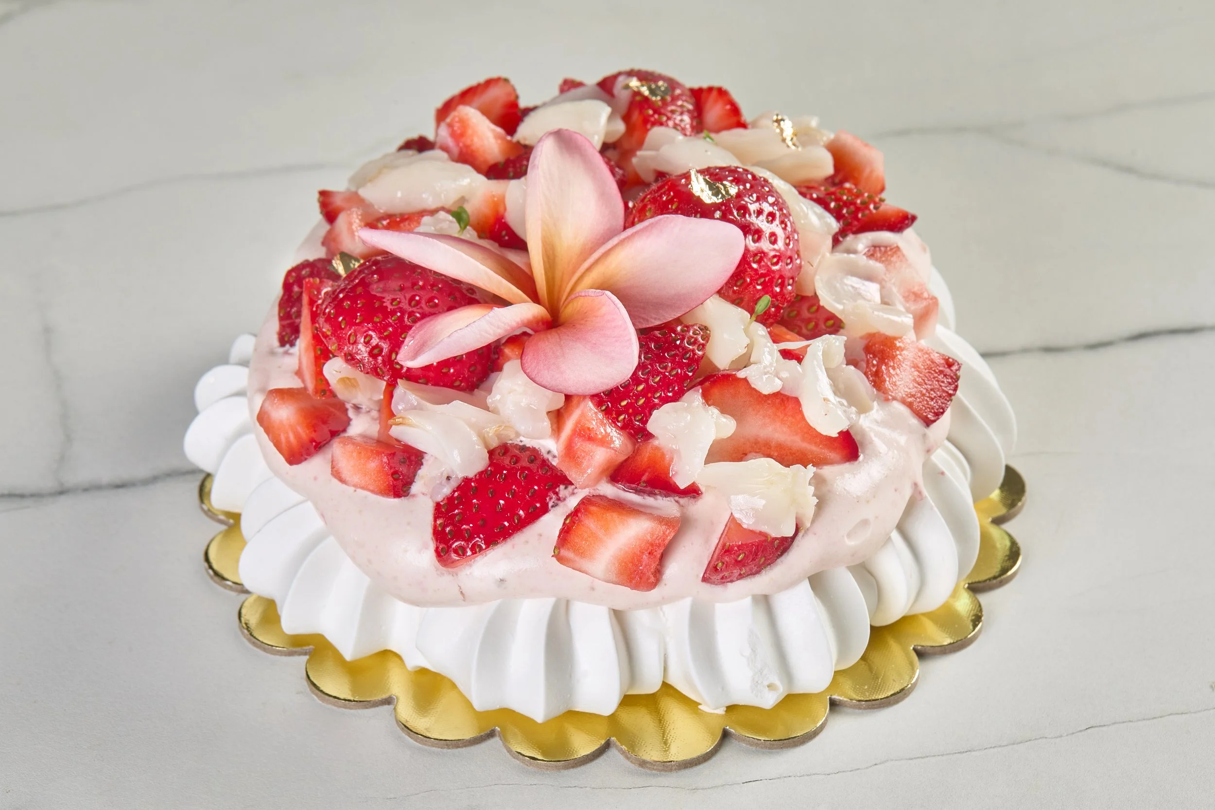 Pastel de pavlova decorado a mano con fruta de temporada.