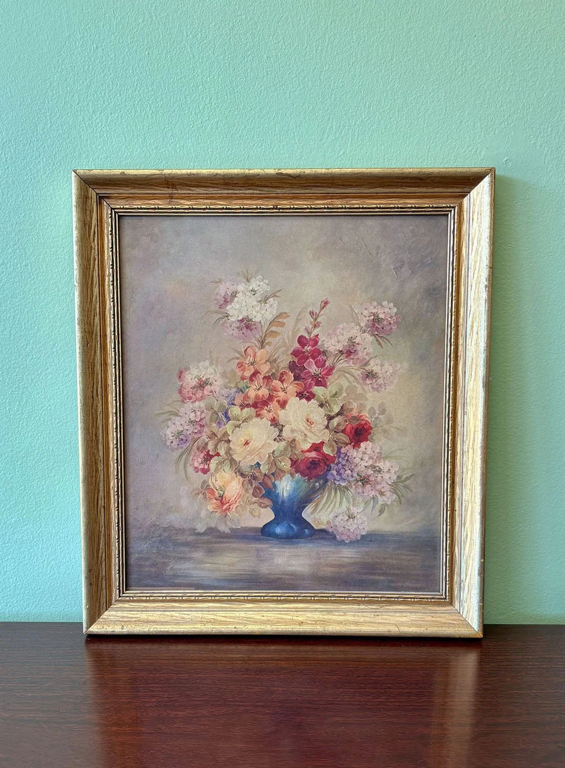 Mid-century soft-focus floral still life oil painting by M. DeCamp in gold frame, against a light aqua background, Evelyn's Emporium Saint Paul